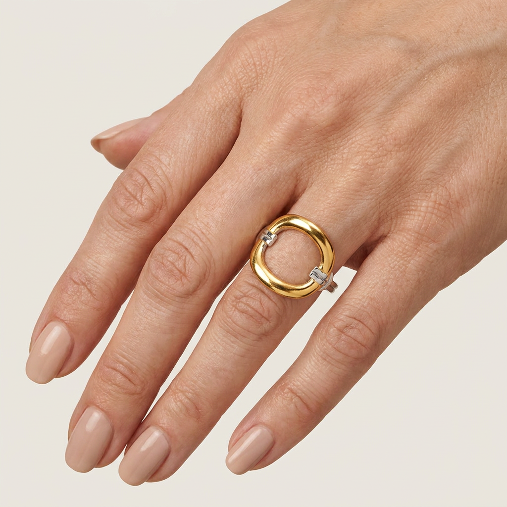 Anillo ovalado ajustable de acero inoxidable bicolor oro y plata con diseño geométrico vintage, sobre fondo blanco