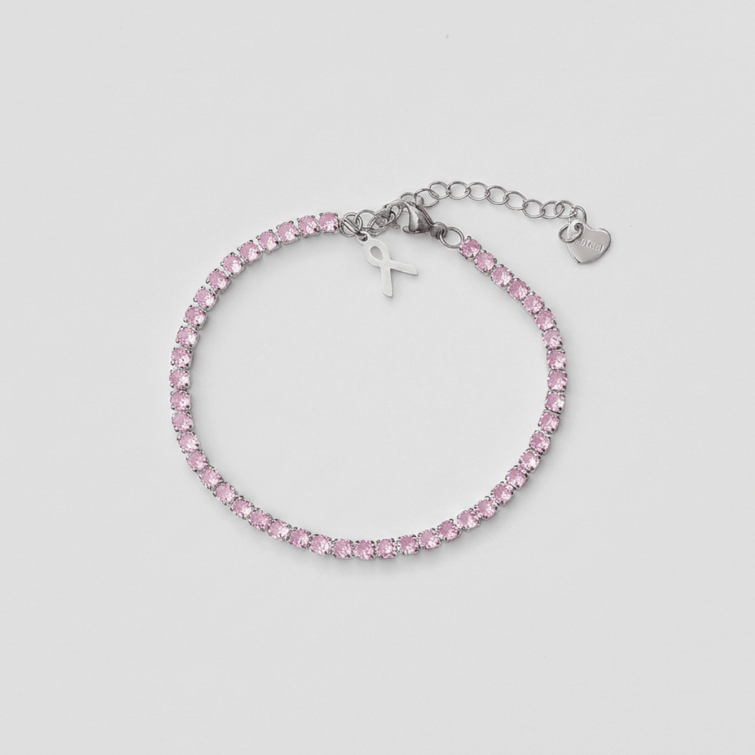 Pulsera PINK 26 de acero inoxidable con circonitas rosas y colgante lazo solidario, cadena ajustable con mosquetón, sobre fondo mármol blanco