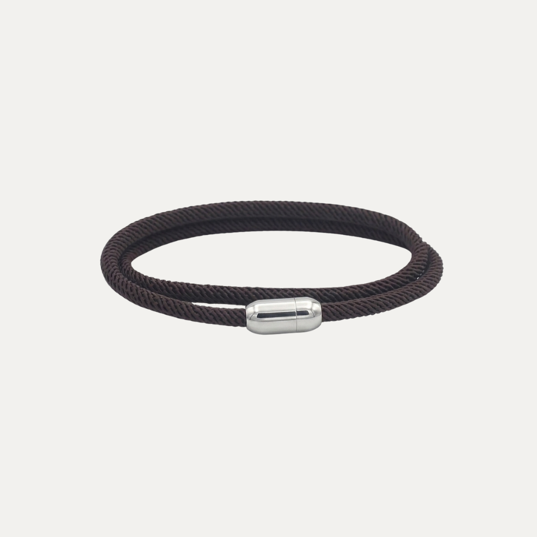 Pulsera de doble vuelta en cuerda Milán trenzada marrón café oscuro con cierre magnético de acero inoxidable plateado, sobre fondo gris claro